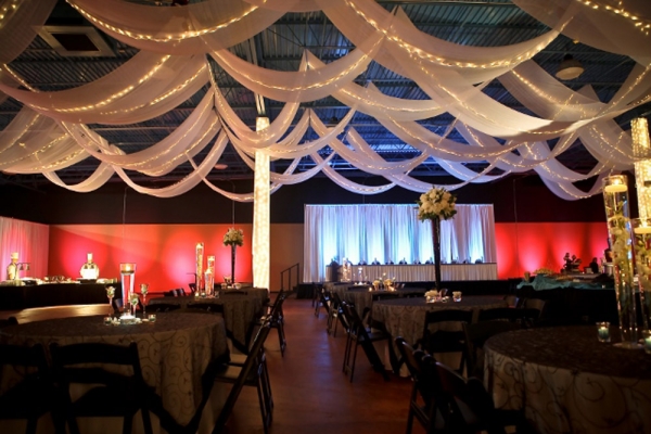 Ceruti’s Banquet & Event Center wedding venue in southwest Fort Wayne, Indiana, featuring elegant ceiling draping, reception tables, and colorful uplighting.