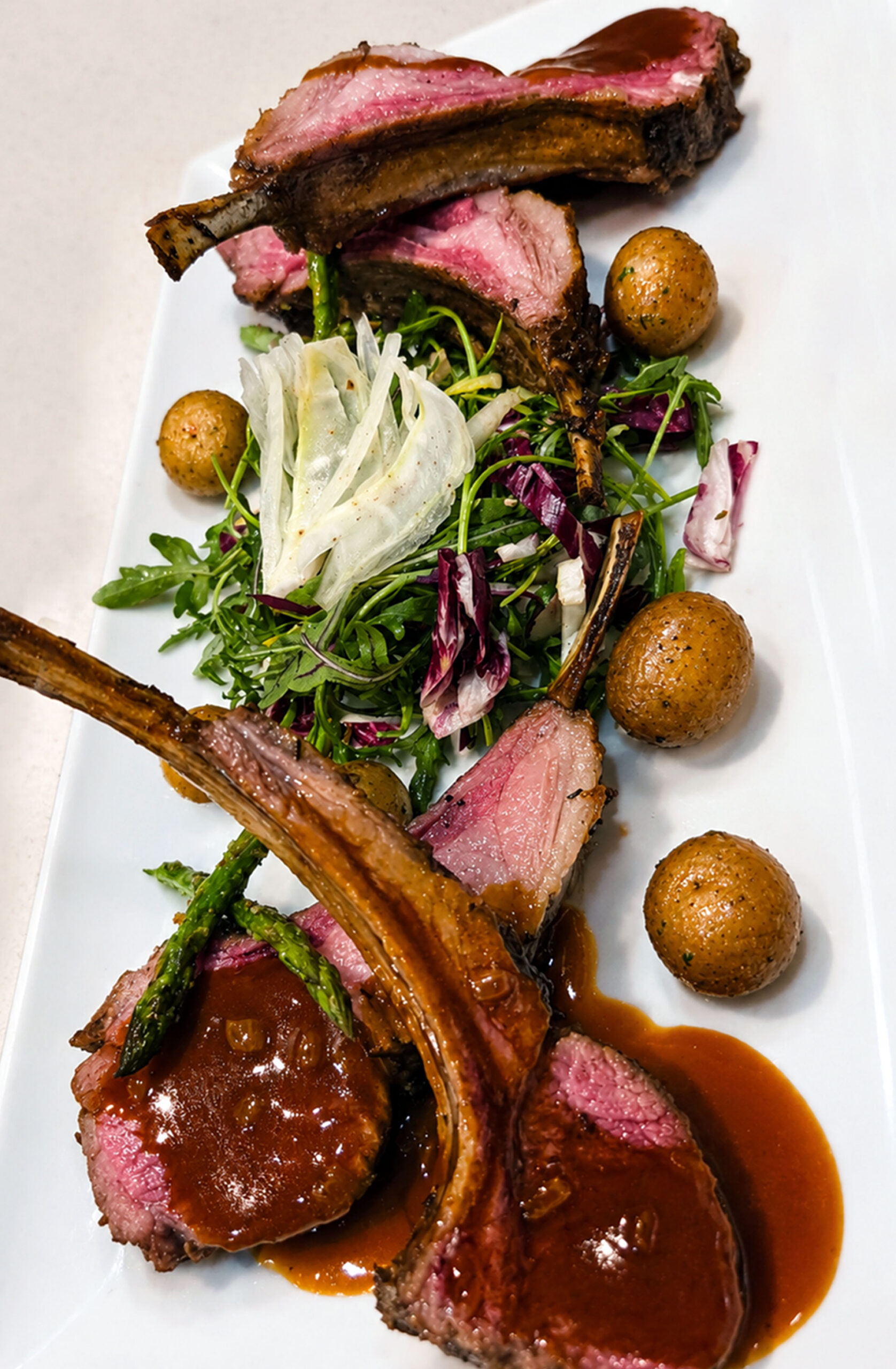 Ceruti’s Catering, Herb roasted whole rack of lamb with a lamb reduction and roasted yukon baby potatoes.